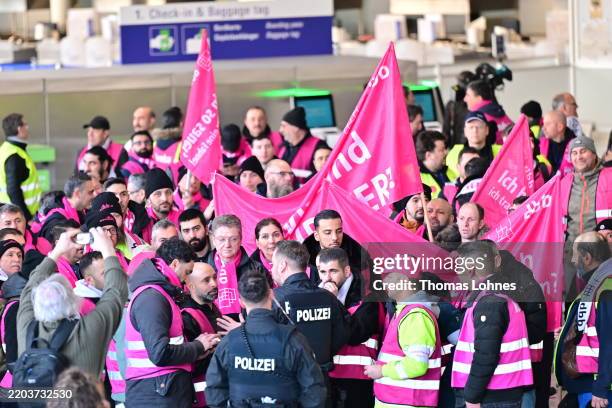 Striking airport workers gather with banners of the Komba labour union at Frankfurt Airport on March 10, 2025 in Frankfurt, Germany. Verdi, which is...