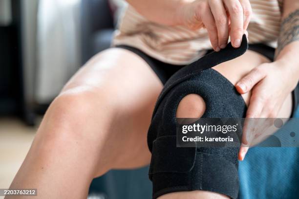 close-up of knee being fitted with brace - kneecap pain stock pictures, royalty-free photos & images