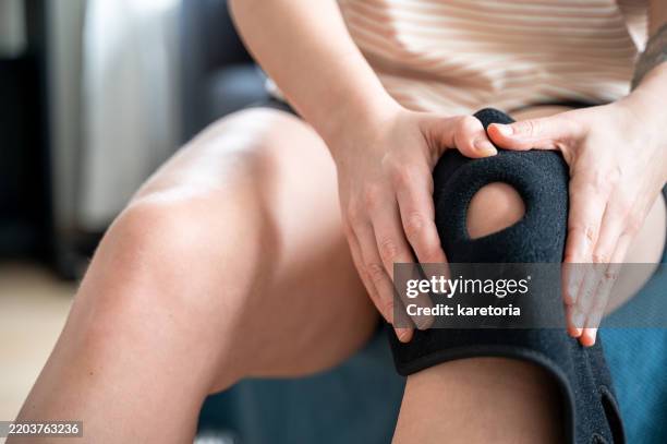 close-up of knee being fitted with brace - kneecap pain stock pictures, royalty-free photos & images