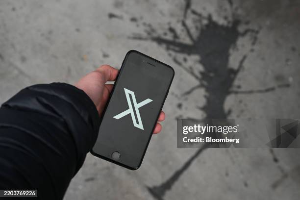 The X logo on a smartphone arranged in London, UK, on Monday, March 10, 2025. User reports indicate X, formerly Twitter, is having issues, according...