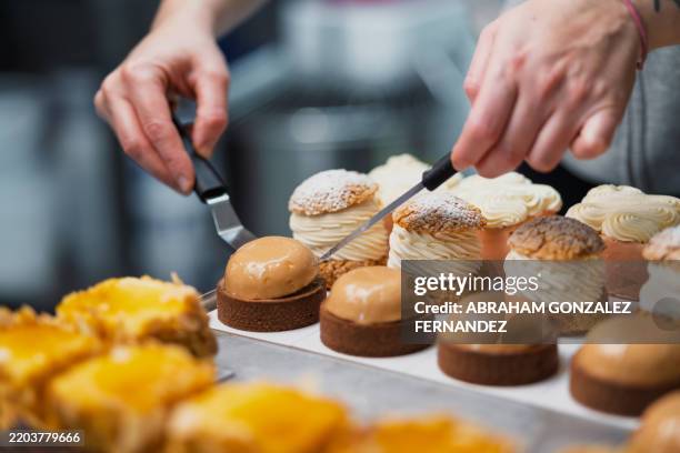 pastry chef carefully positioning cream puffs and tarts, highlighting culinary craftsmanship with delicate, precise arrangement on decorative tray - baked stock pictures, royalty-free photos & images