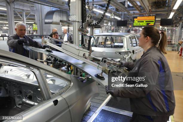 Workers assemble cars on the assembly line at the Volkswagen automobile factory on March 07, 2025 in Wolfsburg, Germany. The factory, which produces...