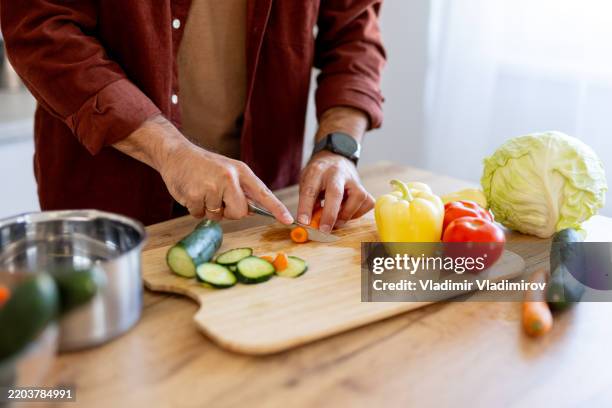 chopping fresh vegetables in a bright kitchen space - guy making salad stock pictures, royalty-free photos & images