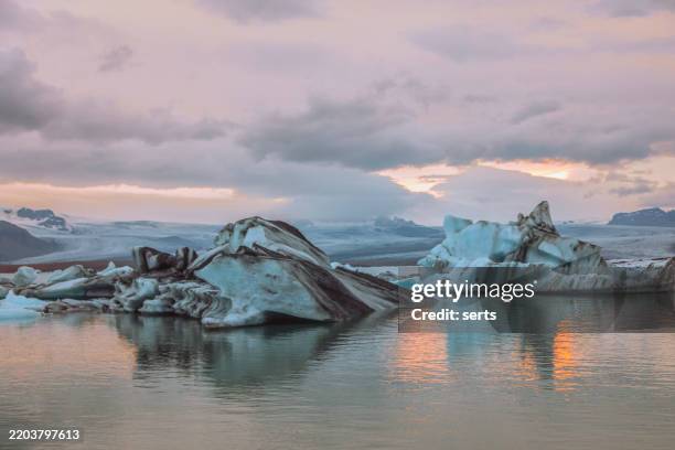 icebergs drifting in jokulsarlon glacier lagoon at sunset, iceland - glacier lagoon stock pictures, royalty-free photos & images