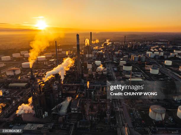 aerial view of fawley oil refinery emitting smoke and steam at sunset, southampton, uk - oil industry stock pictures, royalty-free photos & images