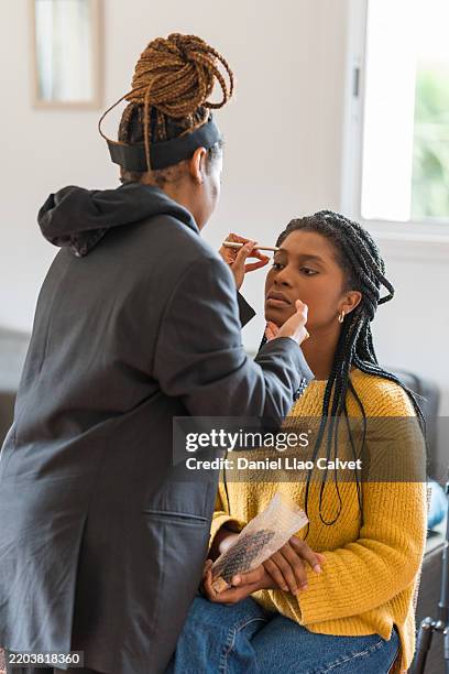 makeup artist applying makeup to model's face with brush - makeup artist stock pictures, royalty-free photos & images