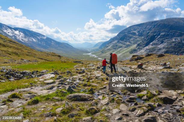 father and daughter with backpacks hiking at tjaktjavagge valley - noord europese etniciteit stockfoto's en -beelden