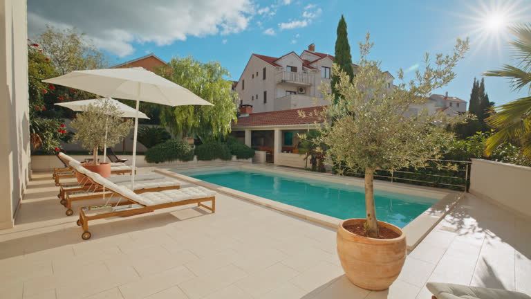 https://media.gettyimages.com/id/2203840294/video/tranquil-private-pool-surrounded-by-lush-greenery-and-bright-sunlight.jpg?b=1&s=640x640&k=20&c=4rtbB2k1x_9_tHxYS9G67bqvqQFSTCBVYdhlW9Cte2E=