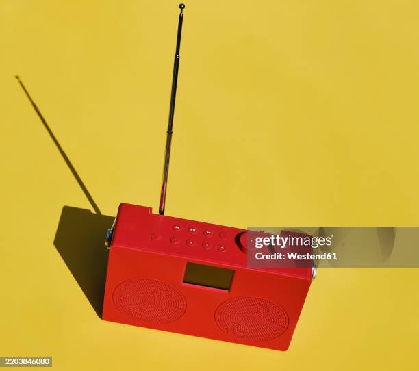 red radio on yellow table - radiogerät stock-fotos und bilder