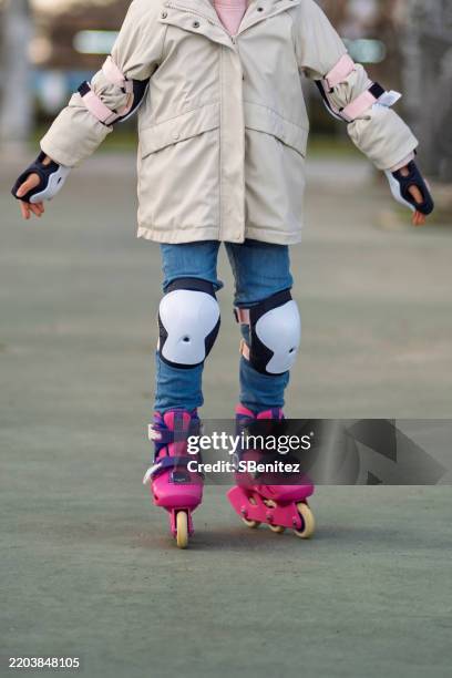 child wearing protective gear while roller skating in park - kneepad stock pictures, royalty-free photos & images