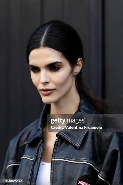 Guest wears a white tank top and a black leather bomber outside Nina Ricci during the Womenswear Fall/Winter 2025/2026 as part of Paris Fashion Week...