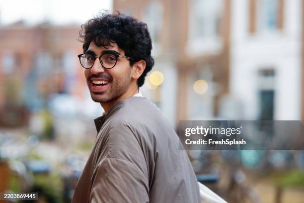 smiling man outdoors in an urban setting on a bright day - high key stock pictures, royalty-free photos & images