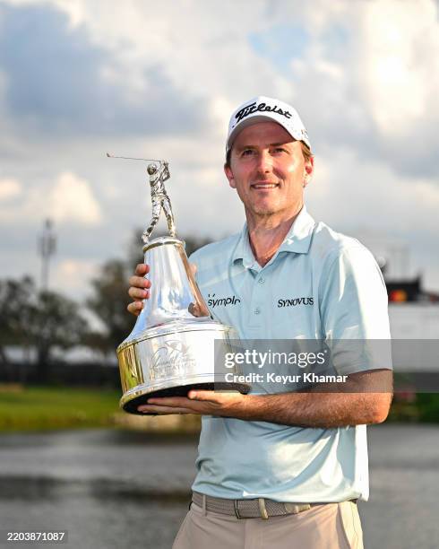 Russell Henley smiles with the tournament trophy following his one stroke victory in the final round of the Arnold Palmer Invitational presented by...