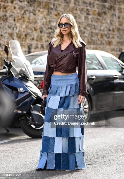 Aikaterini Evangelinou is seen wearing a maroon leather jacket, cut out denim skirt and black sunglasses outside the Nina Ricci show during the...