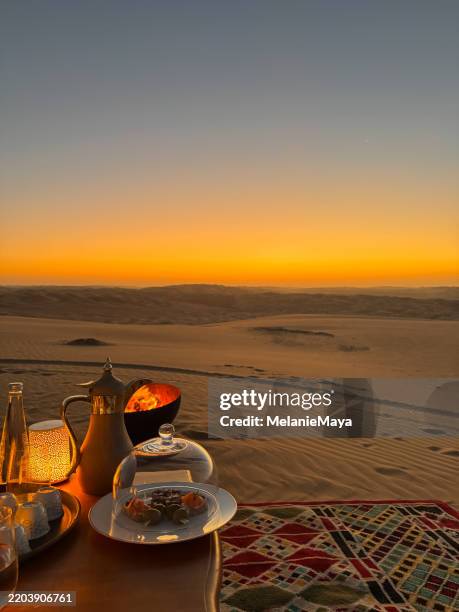 snack canapés and coffee served near bonfire in abu dhabi liwa desert sand dunes for romantic sunset moment excursion - saara imagens e fotografias de stock