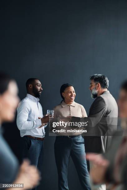 un grupo de profesionales diversos que hacen networking durante un evento de negocios - evento fotografías e imágenes de stock
