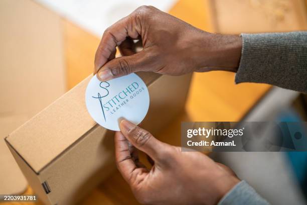 mid adult noir mâle produits d’emballage pour expédition à l’intérieur - étiqueter photos et images de collection