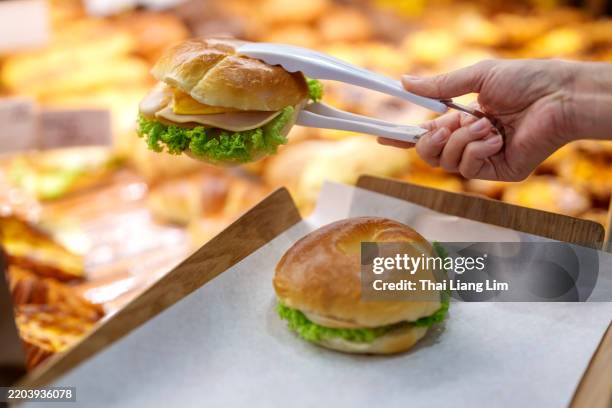 freshly picked bagels and croissant at a bakery - tongs stock pictures, royalty-free photos & images