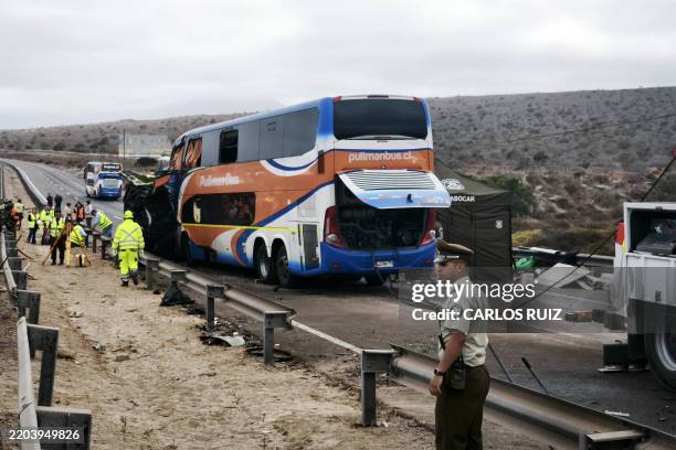 Firefighters and police officers work at the scene of a road collision involving four passenger buses at Route 5 north near the city of Coquimbo,...