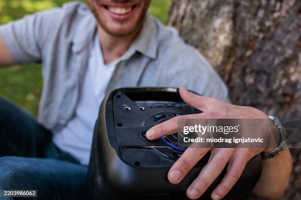 man powering up wireless speaker - wireless speaker man stock pictures, royalty-free photos & images