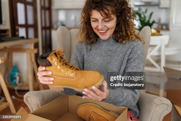 happy woman unpacking box after online shopping - boot stock pictures, royalty-free photos & images
