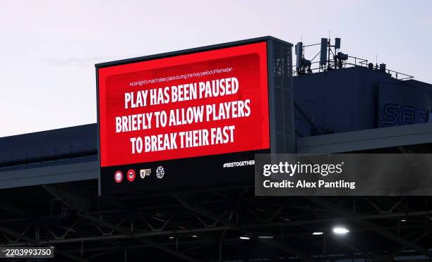 Screen indicates that play is paused to allow muslim players to break their Ramadan fast during the Premier League match between Brentford FC and...