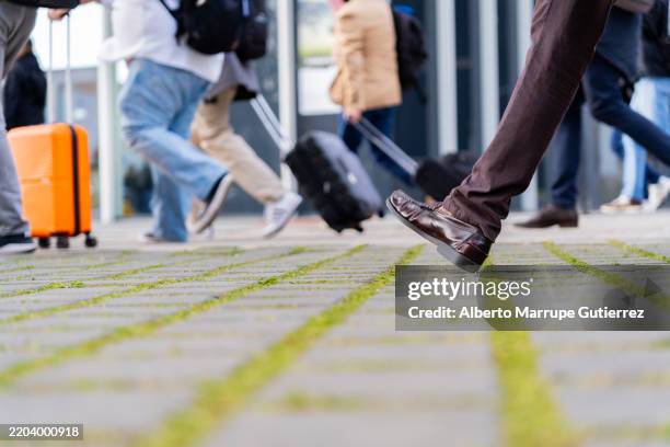 acera urbana peatonal profesional, viajeros borrosos con equipaje que señalan el impulso de los viajes corporativos - mocasín americano fotografías e imágenes de stock