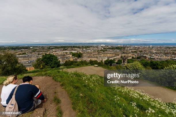 Couple sits on Calton Hill watching the Edinburgh view in Edinburgh, Great Britain, on May 20, 2024.