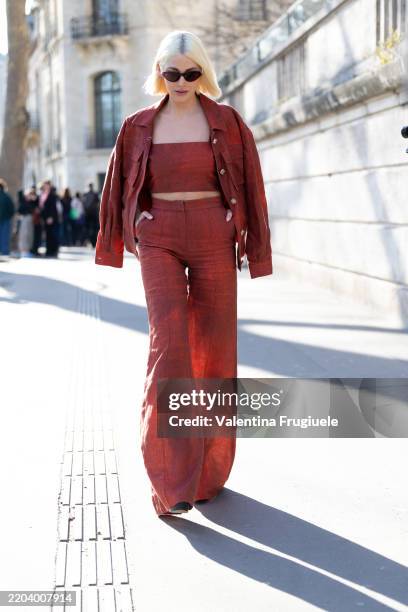 Guest wears black heels, brown sunglasses, a terracotta pink shoulder-less top, a terracotta cargo jacket and terracotta high waist flared trousers...