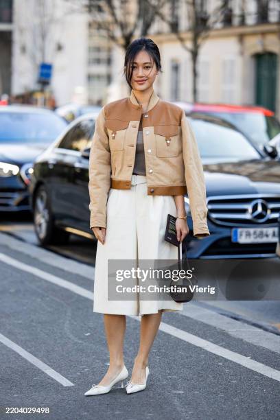 Jihoon Kim wears beige brown leather two tone jacket, white wide leg shorts, micro bag outside Hermes during the Womenswear Fall/Winter 2025/2026 as...