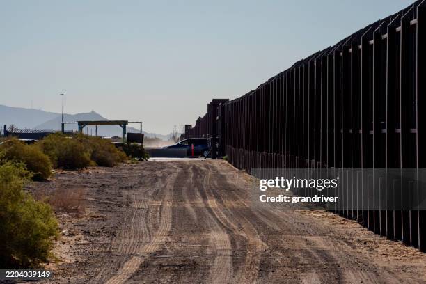 car passing the international border barrier wall between the united states and mexico in santa teresa new mexico at the international crossing site - frame border stock pictures, royalty-free photos & images