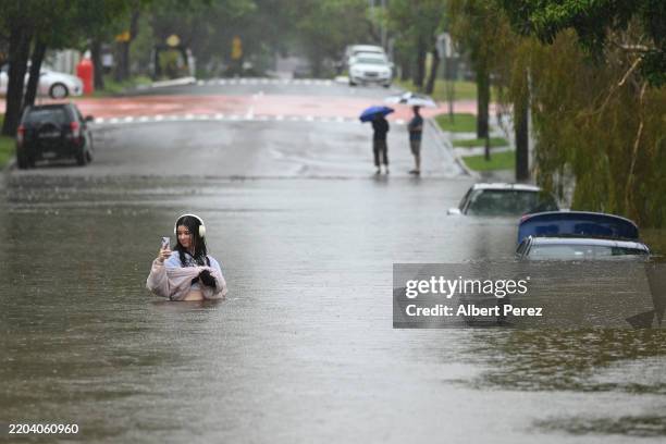Resident walks on a flooded Edmonstone Street in the suburb of Newmarket on March 09, 2025 in Brisbane, Australia. Australia's east coast is...