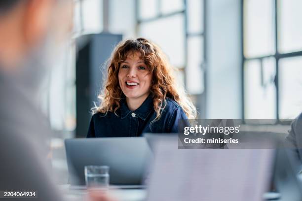 portrait of a smiling professional woman in a modern office setting - skrivbord bildbanksfoton och bilder