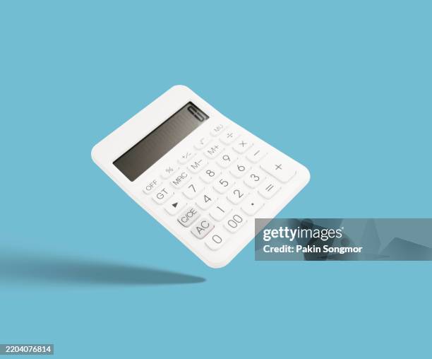a white calculator on blue background with shadow. - rechenmaschine stock-fotos und bilder