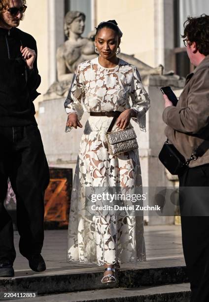 Guest is seen wearing a laced sheer white floral Elie Saab dress, Elie Saab bag and white heels outside the Elie Saab show during the Womenswear...