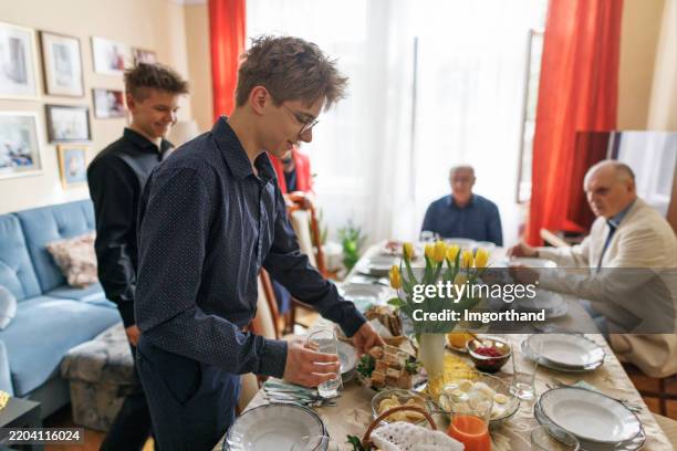 teenagers setting the table for traditional easter breakfast - easter breakfast stock pictures, royalty-free photos & images