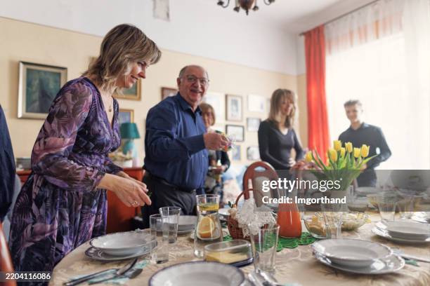 multi generation family setting the table for traditional easter breakfast - easter breakfast stock pictures, royalty-free photos & images