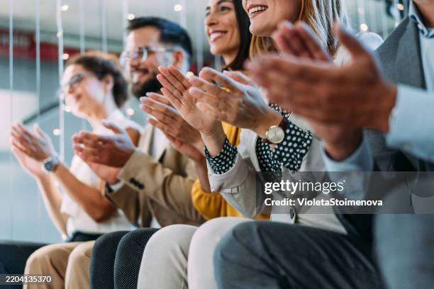 businesspeople applauding during a seminar in conference hall. - applauding stock pictures, royalty-free photos & images