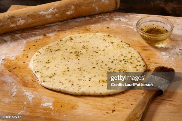 preparing the viral italian pizza dough sandwich - pennello per condimenti foto e immagini stock