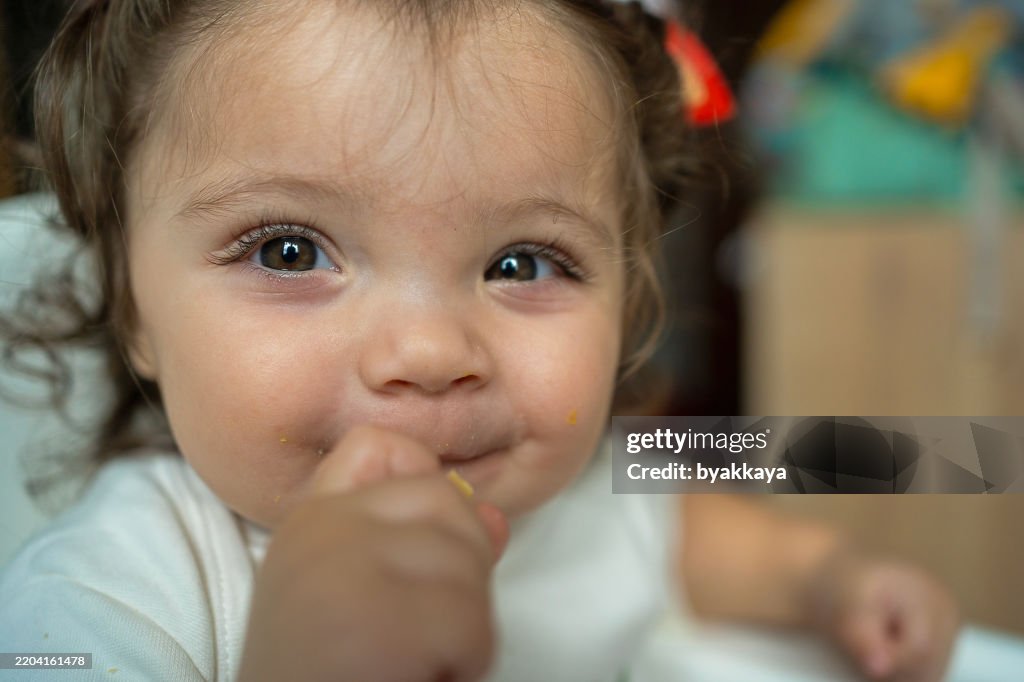 Bebê adorável - idade humana sorrindo enquanto come