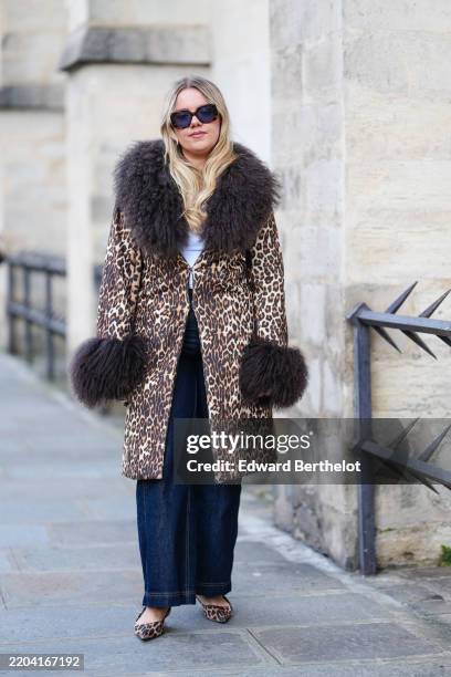 Guest wears dark brown sunglasses, white t-shirt, dark brown leopard pattern/print dark brown faux fur collar cuff coat, navy blue loose denim jean...