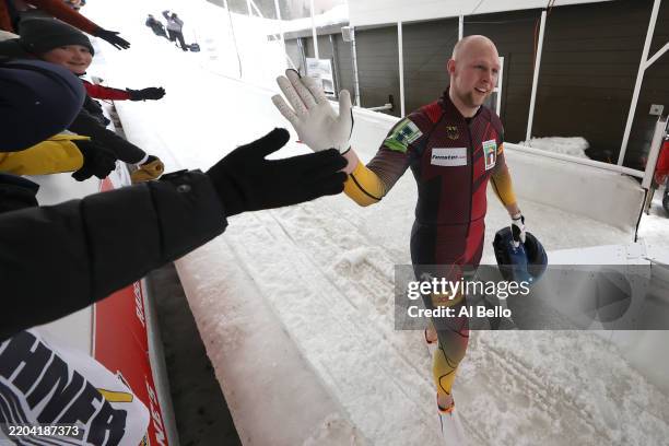 Alexander Schuller of Team Germany celebrates with fans after winning the gold medal following the 2-Man Bobsleigh Race Heat during the 2-Man...