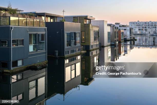 modern floating homes on calm water - calm water stock pictures, royalty-free photos & images
