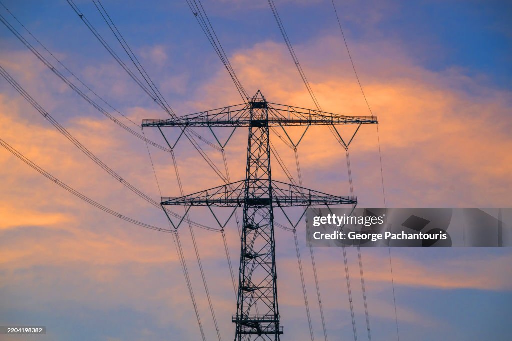 Electricity pylon and power lines at sunset