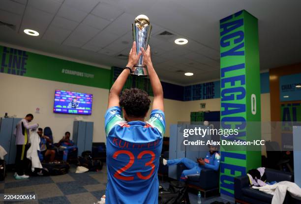 Kuldeep Yadav of India poses with the ICC Champions Trophy in the Changing Room after victory in the ICC Champions Trophy Final match between India...