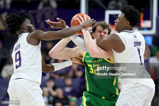 Zoom Diallo and Great Osobor of the Washington Huskies defend Nate Bittle of the Oregon Ducks in overtime at Alaska Airlines Arena on March 09, 2025...