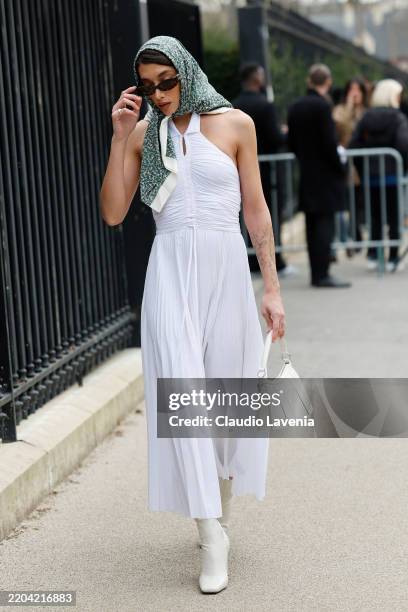 Penélope Guerrero wears white Lacoste maxi dress, cream and green printed silky Lacoste scarf, white boots, white Lacoste bag, outside Lacoste,...