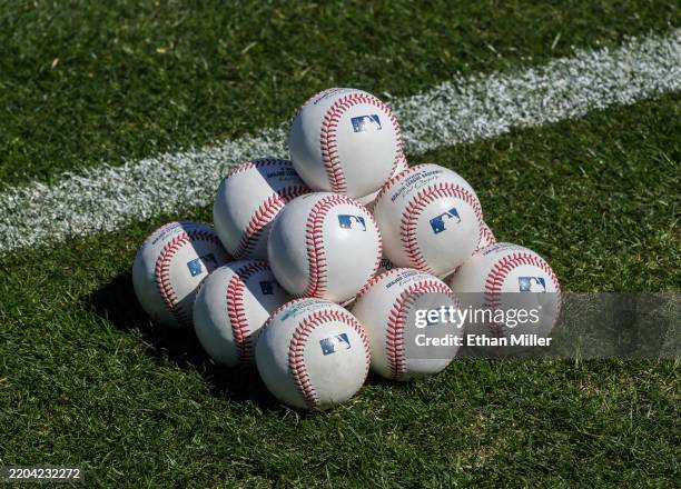 Baseballs are stacked on the field before a spring training game between the Arizona Diamondbacks and the Athletics at Las Vegas Ballpark on March...