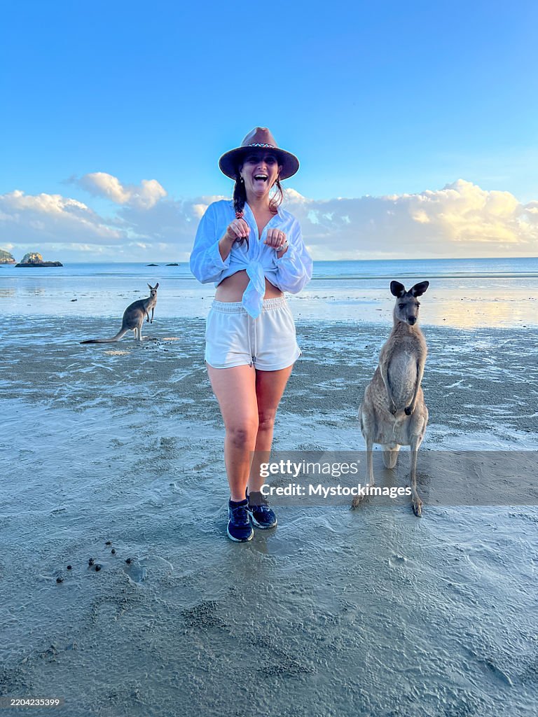 Woman on Beach with Kangaroos at Sunset