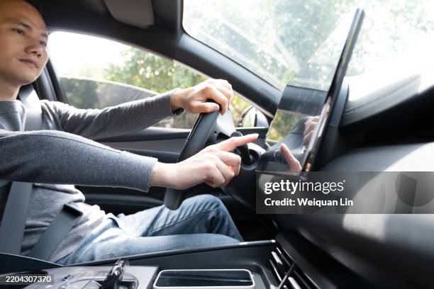 asian driving a car - driverless car stock pictures, royalty-free photos & images